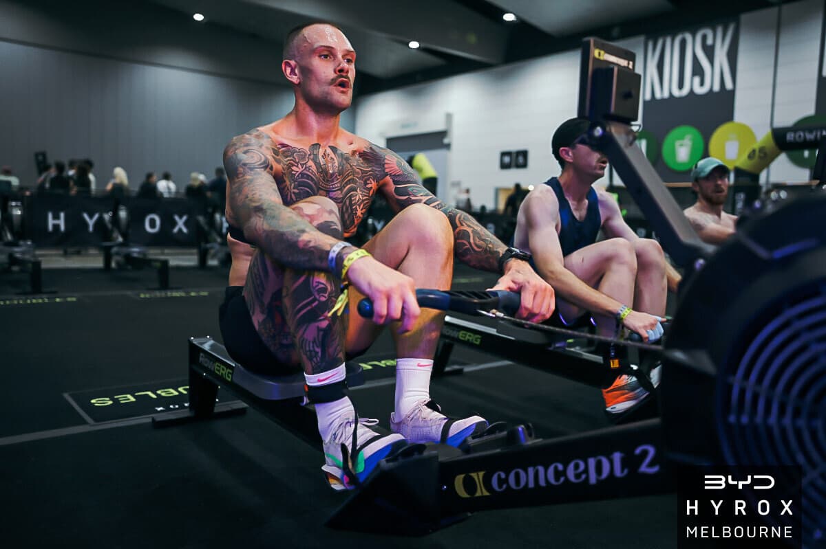 Jordon Mudge working the rower during a HYROX race